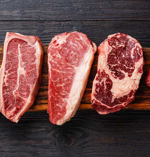 five pieces of raw meat on a cutting board