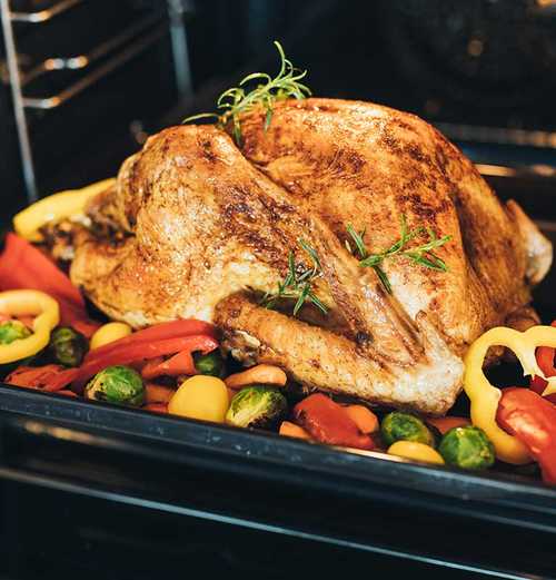 cooked turkey with vegetables in an oven