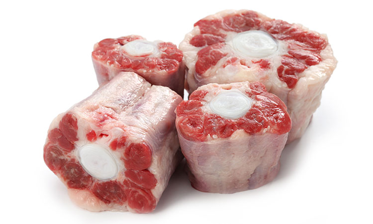 A picture of four cuts of oxtail, arranged close together