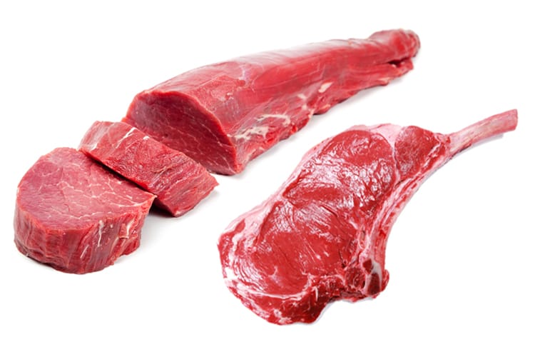 A top down picture of a steak with a spring of rosemary, and a bunch of salt crystals and white pepper corns