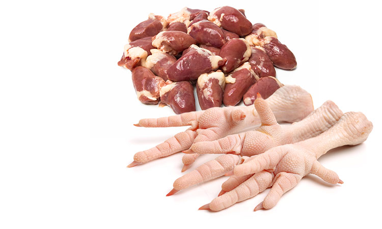 A pile of raw chicken hearts behind three raw chicken feet lined up together